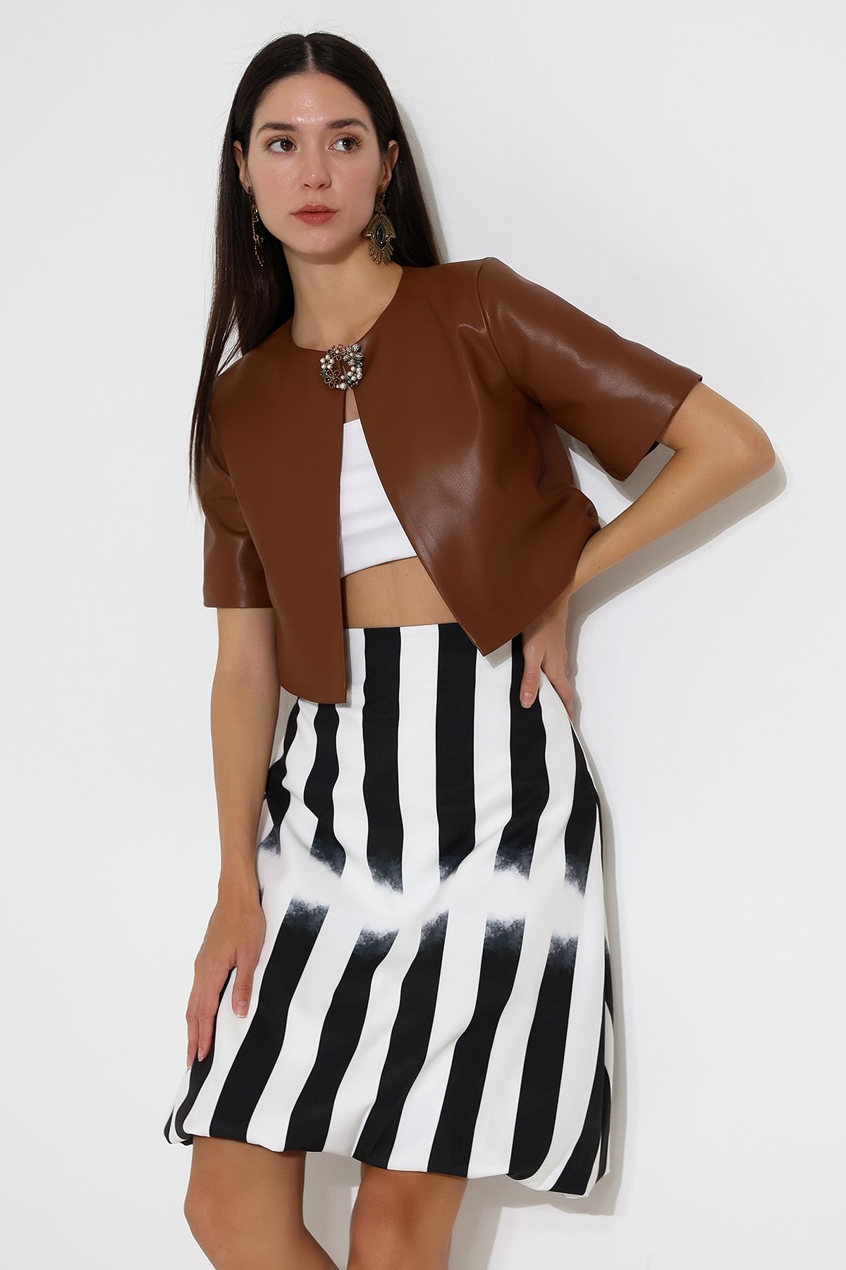 modèle en boléro en cuir et jupe rayée noire et blanche