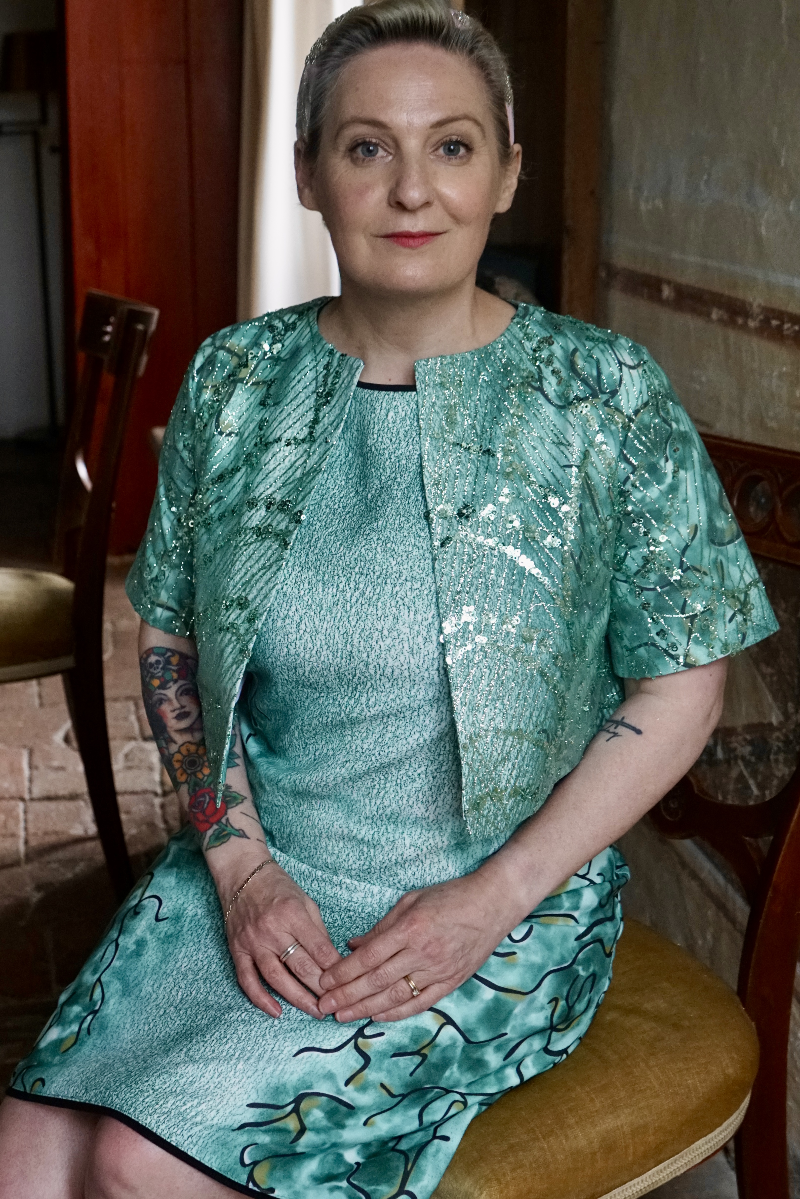 Dos de la robe verte à motifs et de la veste nacrée