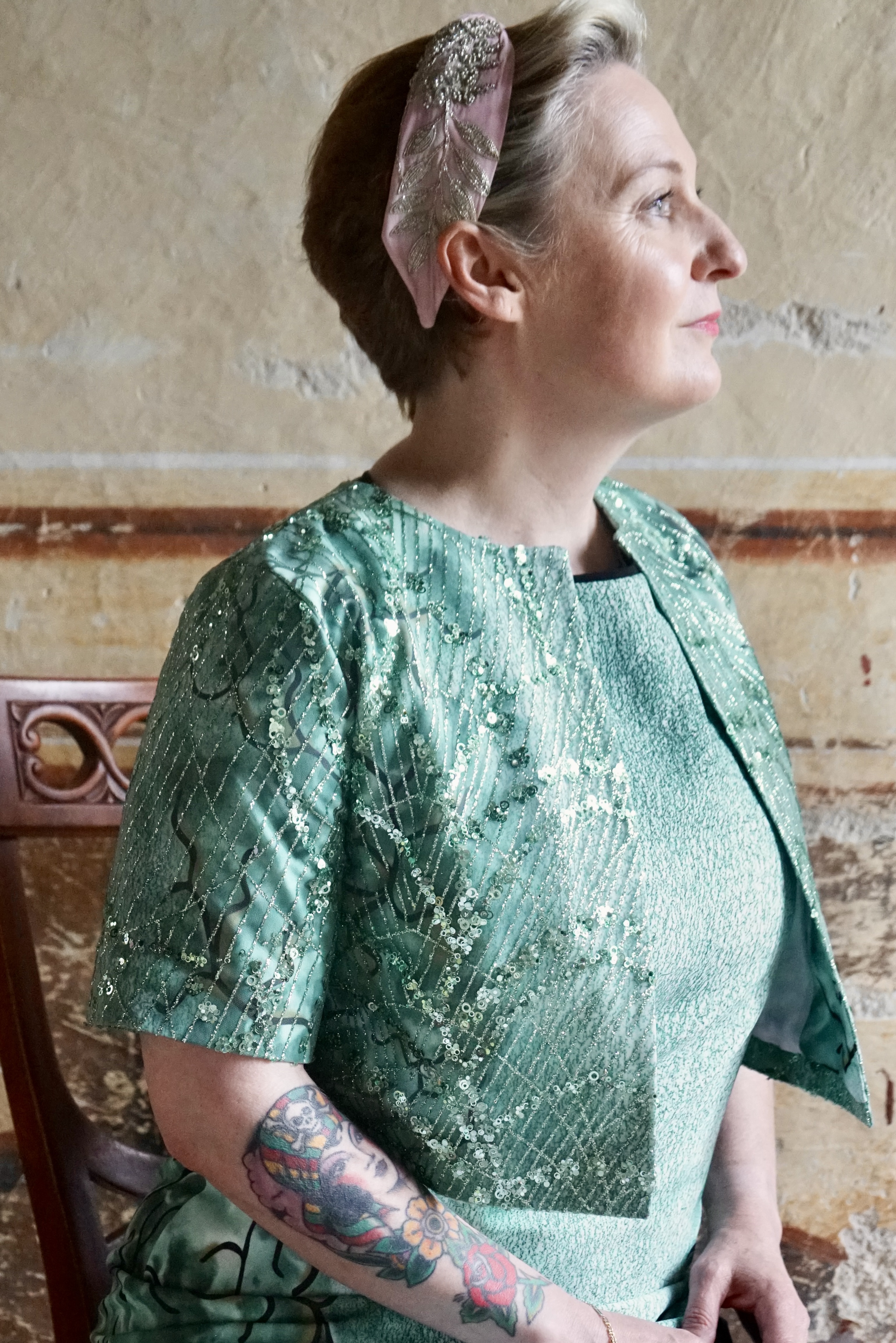 Gros plan sur la veste nacrée de la robe verte