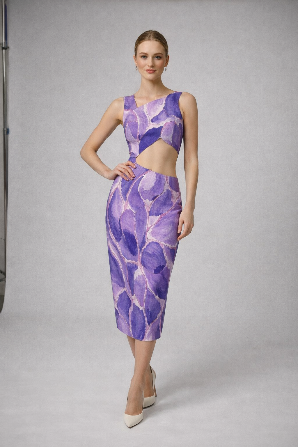Mannequin en robe d'été mi-longue à coupe droite, motif violet audacieux, corsage asymétrique dévoilant le ventre.